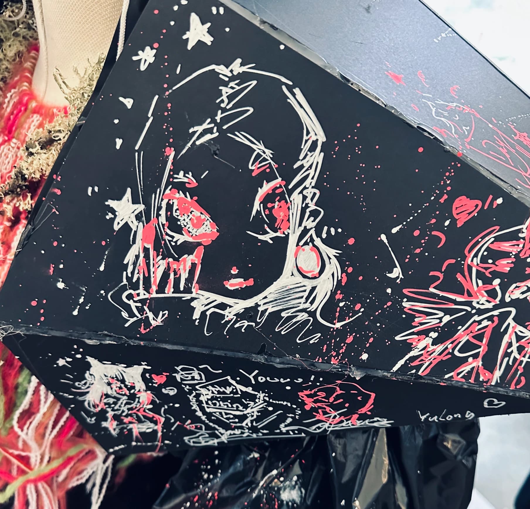 Portrait drawing on a black angular surface.