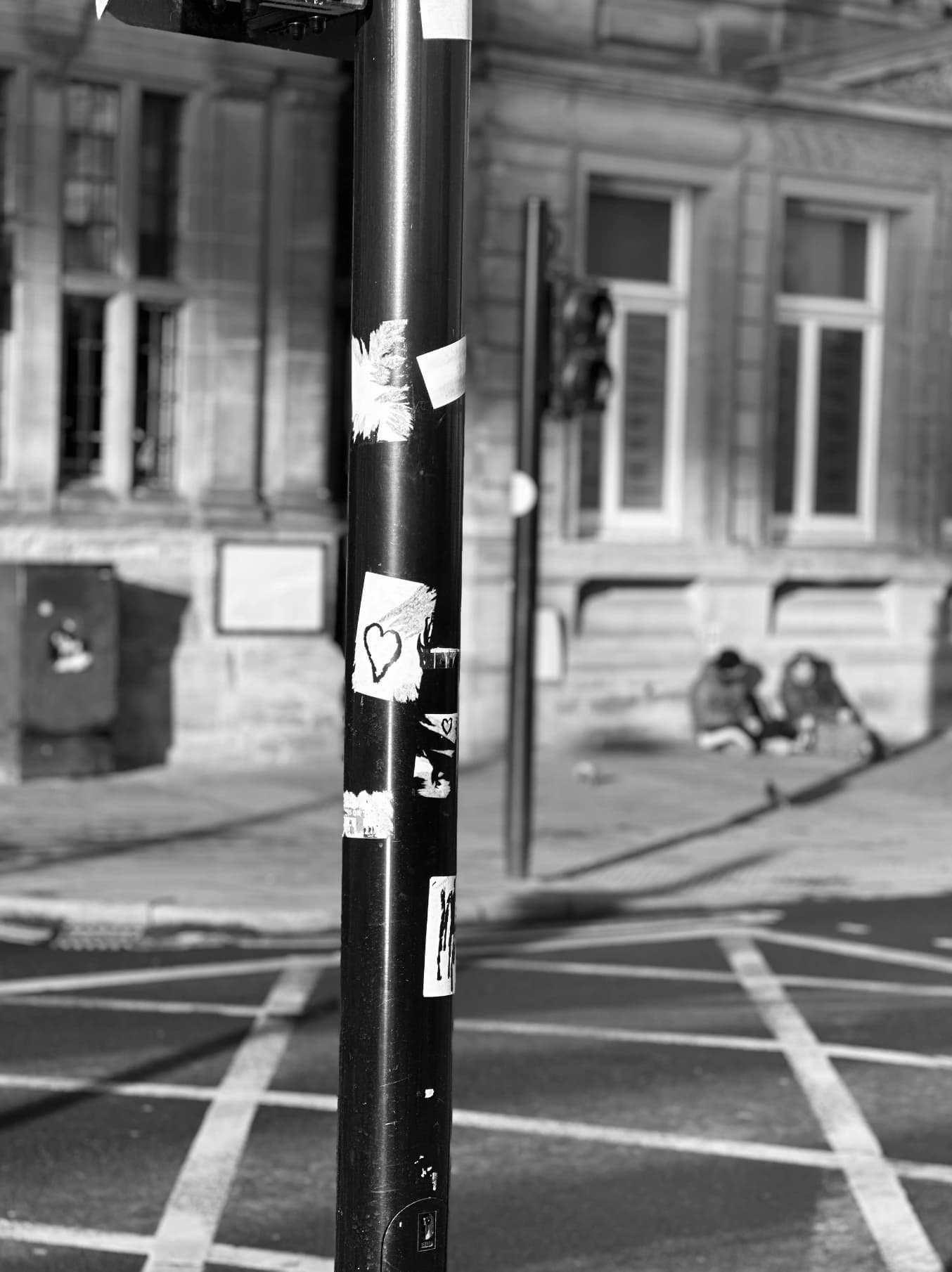 Black-and-white street crossing with a pedestrian signal.