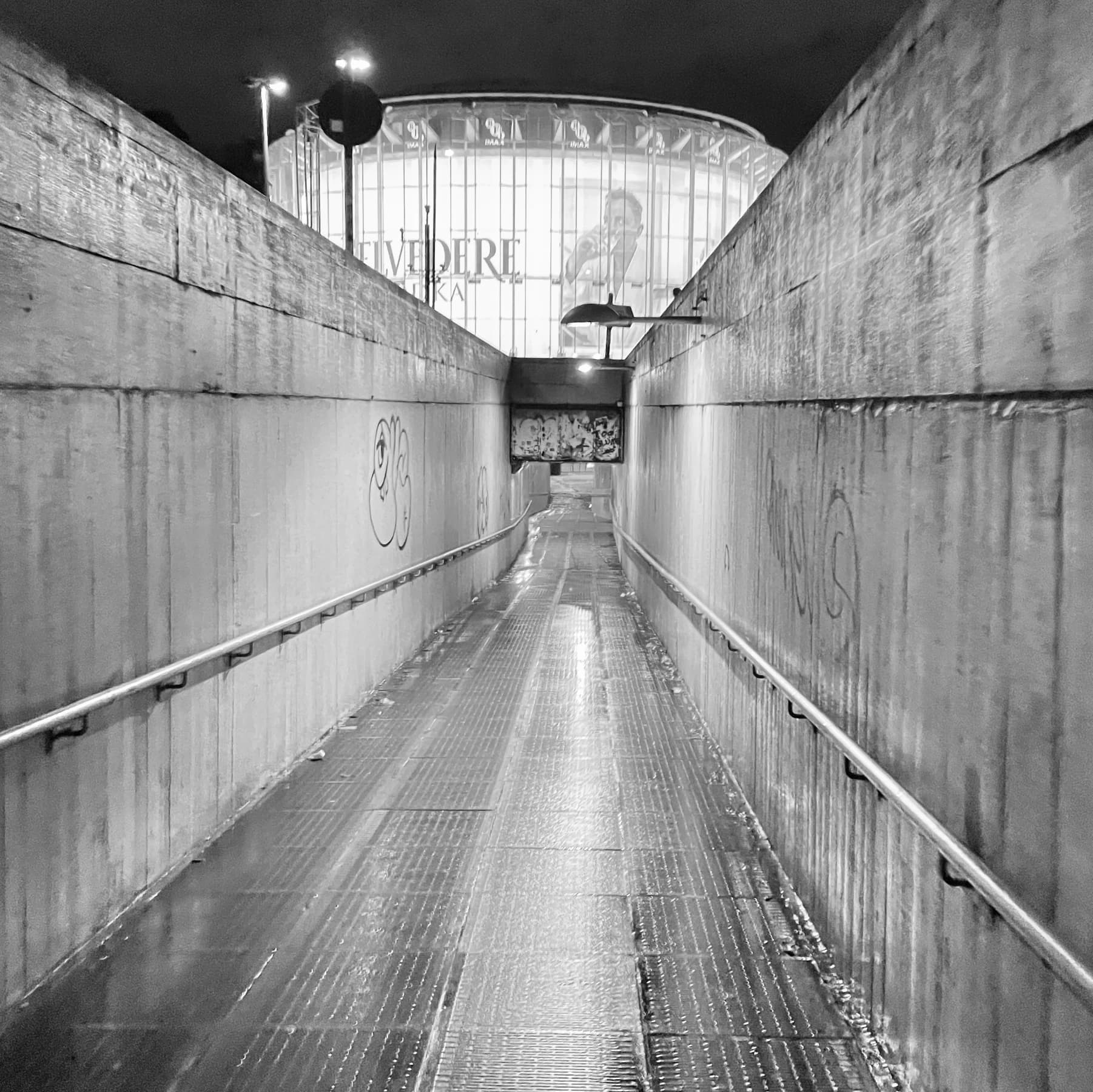 Black-and-white passage with steps and handrails.