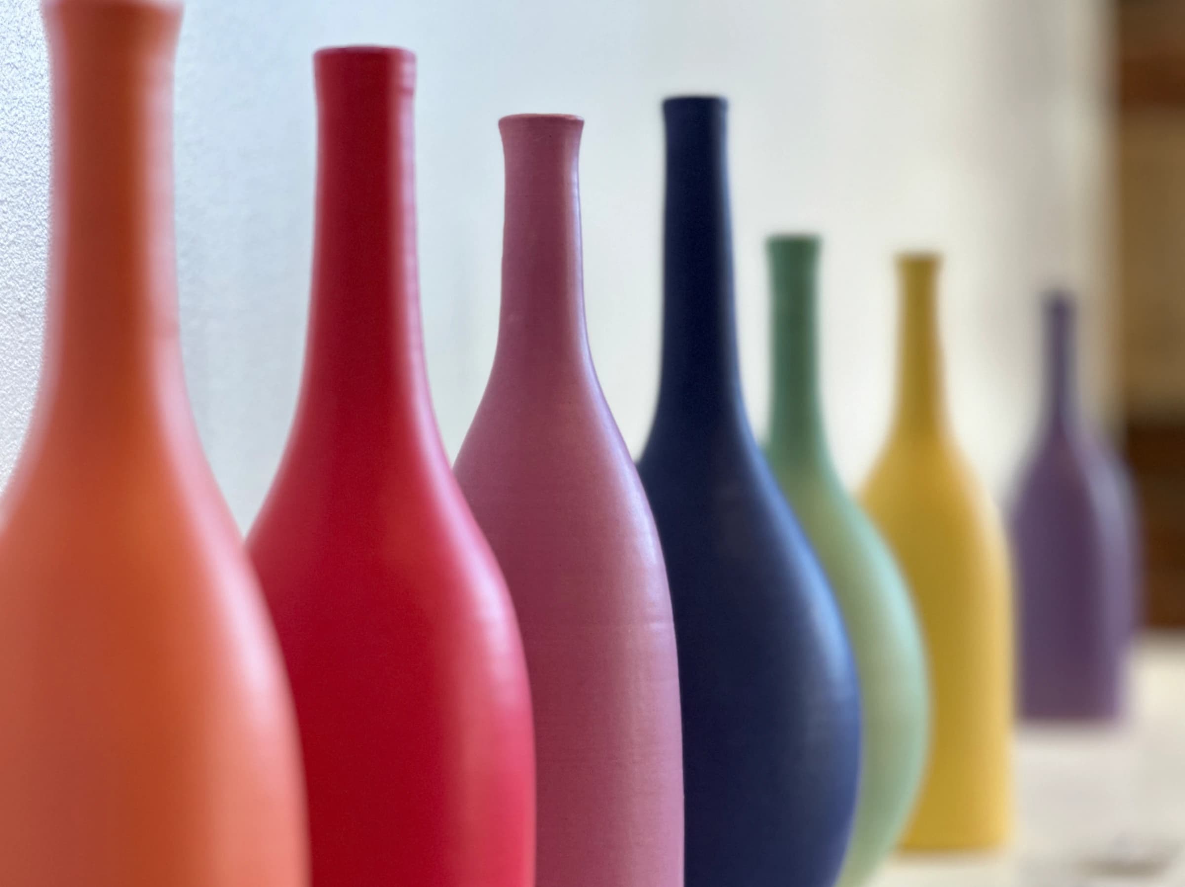 A row of colourful bottles fading out of focus.