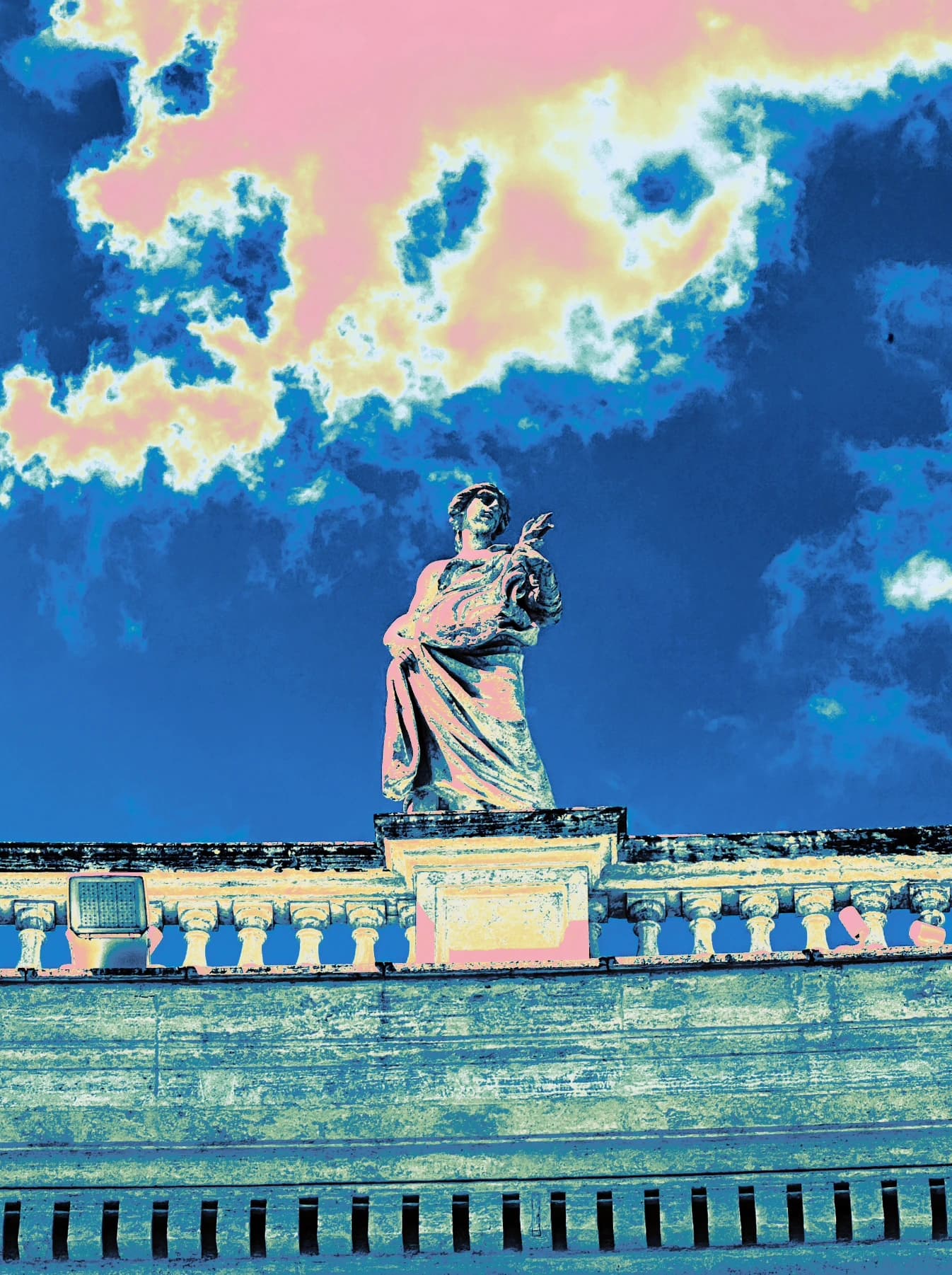 Rooftop statue and clouds in blue and yellow tones.