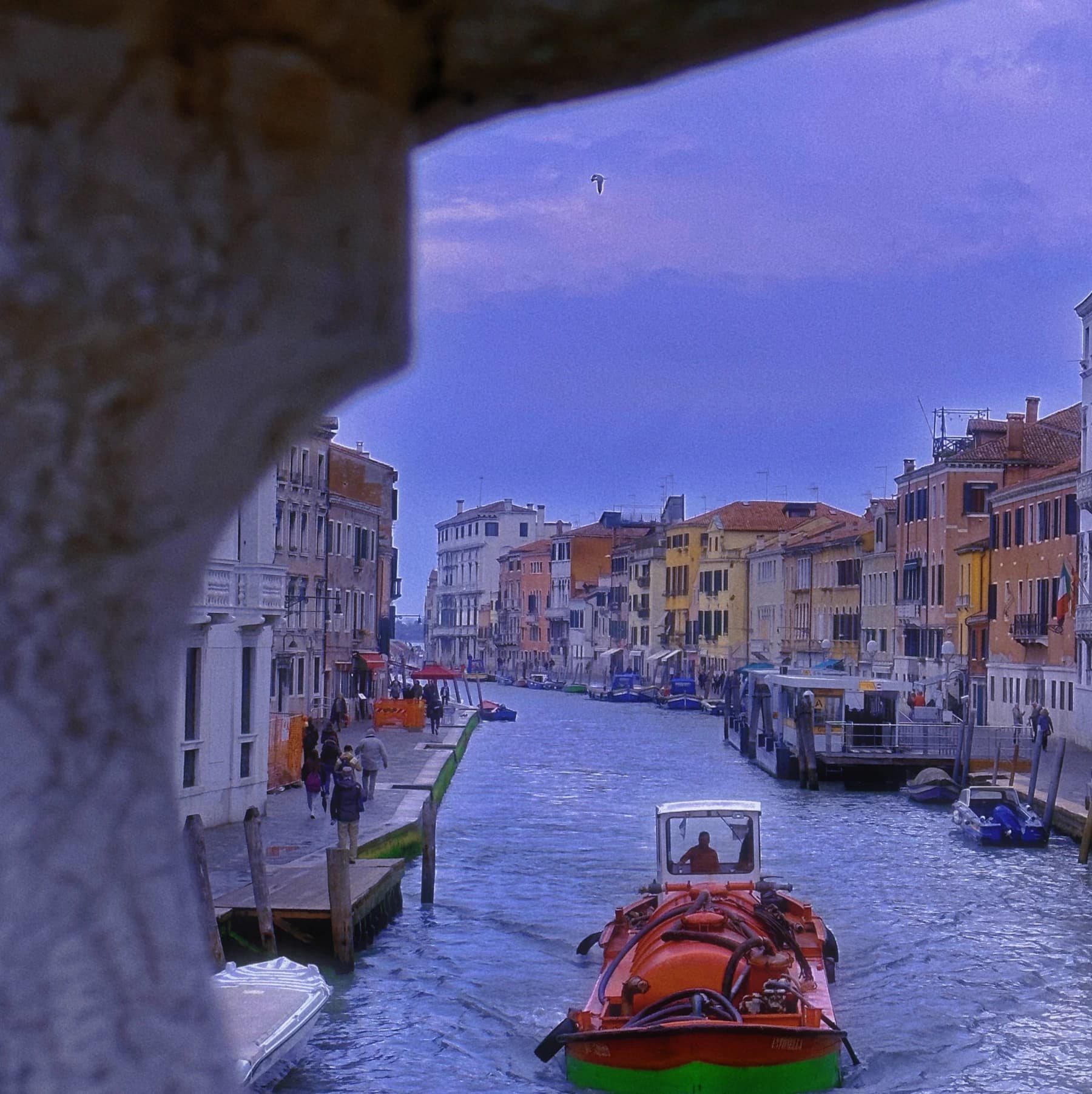 Canal and boats seen beneath an arch.